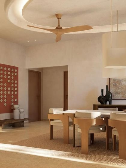 Sunlight filters into the dining space, highlighting the earthy tones and minimal decor. The red art piece adds a deliberate pop of color to the otherwise neutral palette.