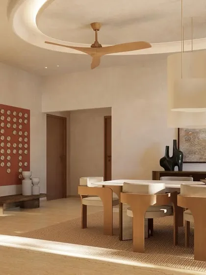 Sunlight filters into the dining space, highlighting the earthy tones and minimal decor. The red art piece adds a deliberate pop of color to the otherwise neutral palette.