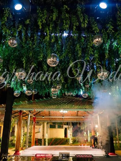 A creative Sangeet stage design with a ceiling of lush greenery and disco balls, creating a 'jungle disco' vibe.
