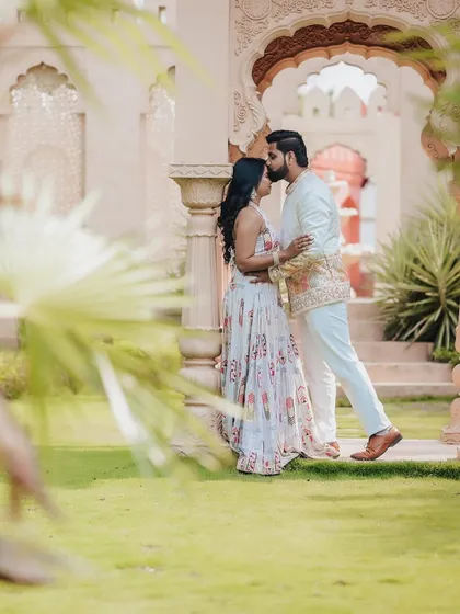 For pre-wedding shoots, I love finding stunning backdrops that reflect the couple's story. Here, the groom's gentle kiss against a backdrop of royal architecture creates a timeless, fine-art portrait filled with romance.