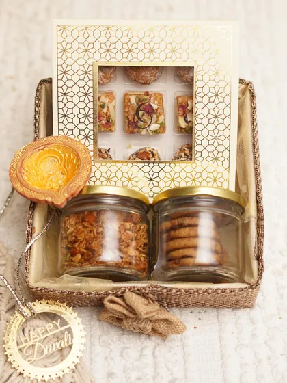This 'Assorted Delight Hamper' for Diwali features jars of our honey almond granola and chocolate chunk cookies alongside a box of traditional handmade sweets, packed in a beautiful jute basket.