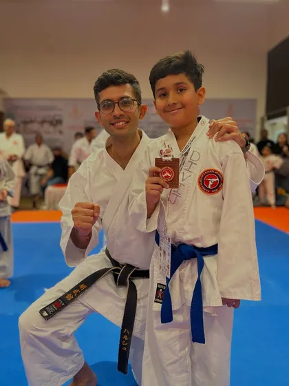 An instructor celebrates with a young bronze medalist. We believe in recognizing effort and encouraging students to always do their best.