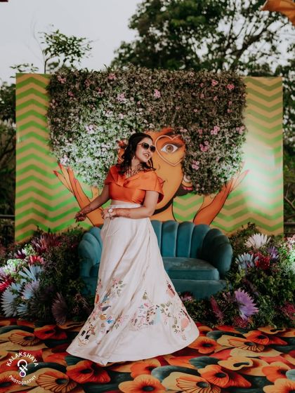 The bride twirling in her custom-designed lehenga in front of a vibrant, artistic backdrop.