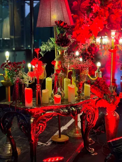 This masquerade-themed party was drenched in dramatic red lighting, with intricate floral centerpieces, candelabras, and even a mirrored mannequin adding to the mysterious and glamorous vibe.