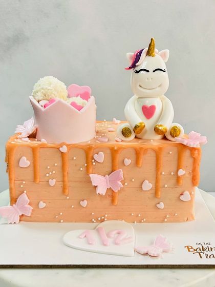 Celebrating a magical half-birthday with this adorable unicorn cake. The design features a cute unicorn, a princess crown, and a soft orange drip.