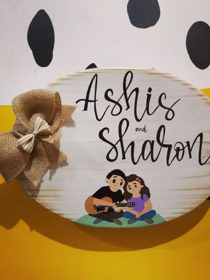 A custom name plaque for a newlywed couple, featuring a sweet illustration of them with a guitar. This piece was a thoughtful gift, capturing a special memory on wood.