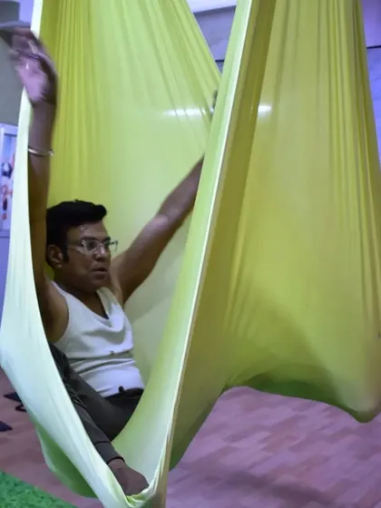 The body achieves what the mind believes. This student finds a moment of calm and focus while seated in the hammock.