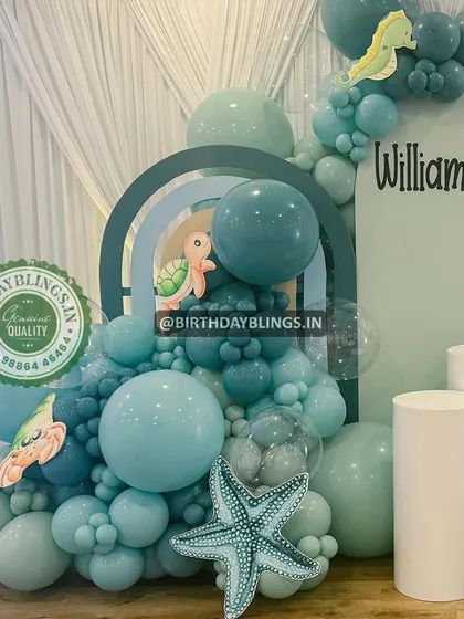 A close-up of an underwater-themed balloon arrangement in shades of teal and seafoam green. The seahorse and starfish details are adorable.