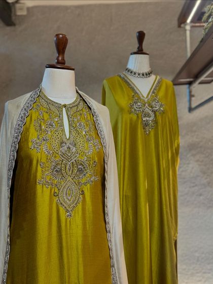 Two elegant Jayanti Reddy outfits in mustard yellow, one a kaftan and the other a kurta set with a sheer cape, both showcasing exquisite embroidery.