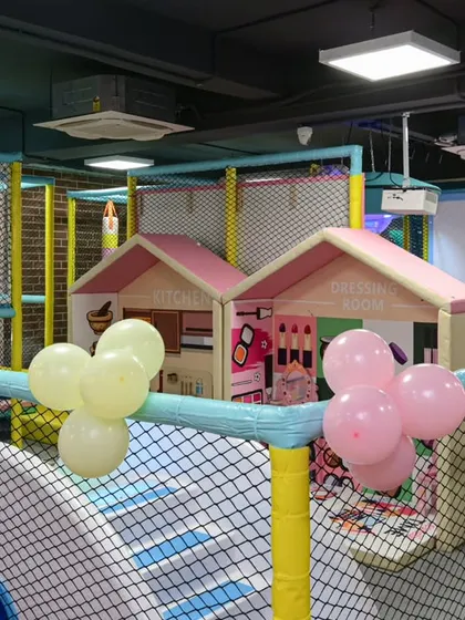 An overview of the play structure, enclosed with high-quality safety nets. You can see the imaginative play houses nestled within the larger adventure zone.