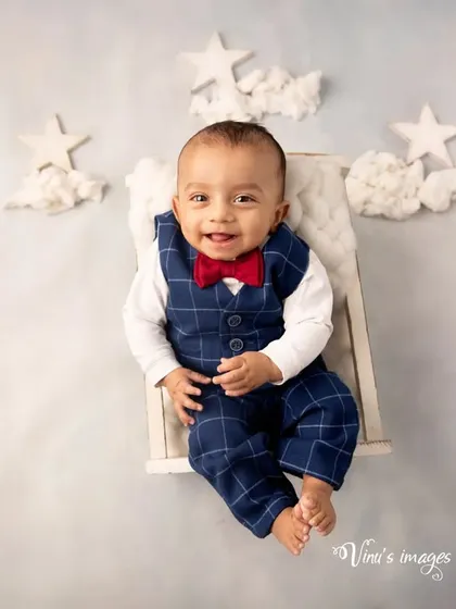 Flying high among the clouds and stars. This creative shot shows the baby sitting on a tiny bench, appearing to float in a dreamy sky.