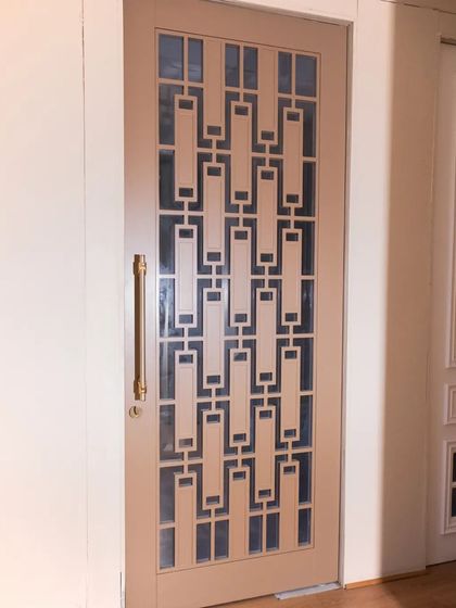 A PU-painted door with a geometric 'jali' and mirror work, showcasing a blend of modern design and traditional craftsmanship.