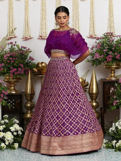 A refreshing take on Bandhej, this purple Banarasi lehenga is paired with a contemporary organza cape blouse.