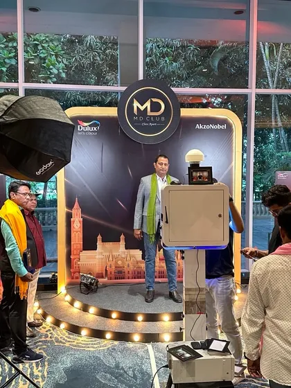 A guest posing at the Dulux Paint MD Club corporate event. The backdrop and photo booth are seamlessly integrated into the event's branding.