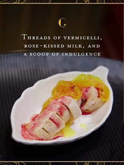 A deconstructed Falooda dessert, featuring rolls of kulfi topped with vermicelli and rose-kissed milk. This innovative presentation elevates a classic Indian sweet into a gourmet experience.
