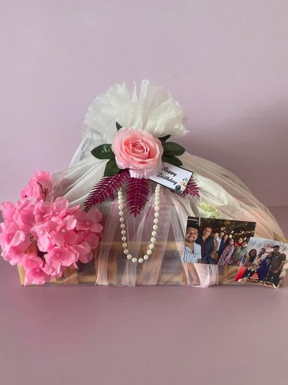 This wooden tray hamper is beautifully wrapped in net with a pearl necklace detail. It's a very elegant way to present a birthday gift.