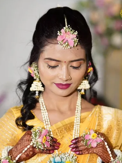 A moment of quiet beauty. The bride's floral maang tika and hathphool are crafted with delicate flowers to create a soft, romantic Haldi look.