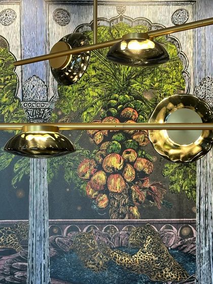 An overhead shot of the Ceto chandelier, its glass discs resembling lily pads floating on a brass branch.