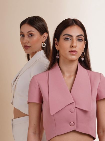 A classic two-model portrait showcasing cropped blazers in pink and white. This highlights the tailored fit and modern design of the pieces.
