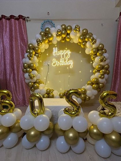 A 'BOSS' themed birthday party with a white and gold circular balloon arch and letter balloons.