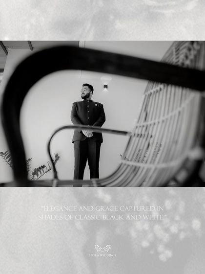 An artistic black and white shot of the groom, capturing a moment of quiet contemplation with creative framing.