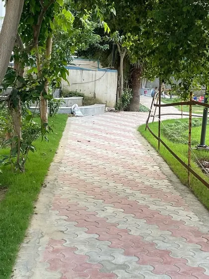 A shady part of the park's walkway, surrounded by established trees and new plantings. This demonstrates how I design paths that work with the natural contours and features of the land.