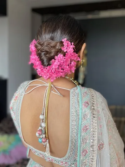 A close-up of the floral wedding bun, highlighting the texture of the bun and the freshness of the flowers.