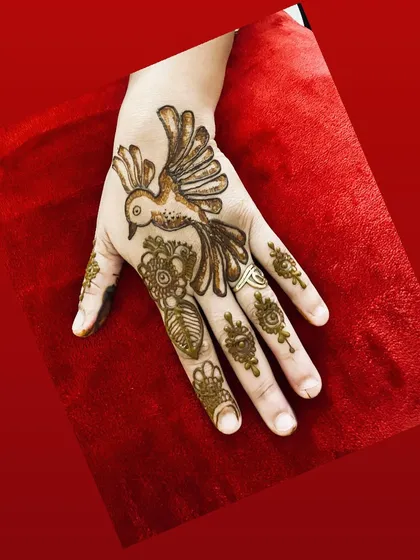 A single, bold bird motif on the back of the hand. This minimalist statement piece is modern, artistic, and perfect for someone who wants a unique design.