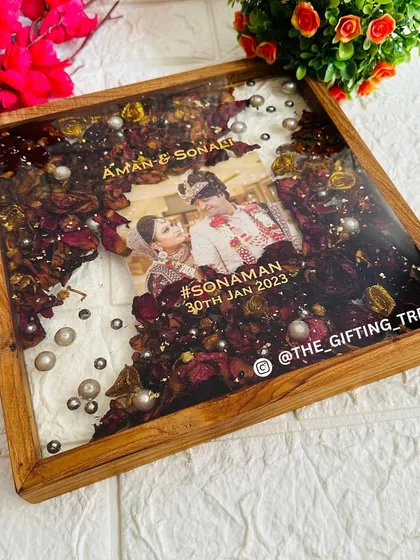 An overhead shot of the square teakwood frame, showing the diagonal design of the preserved flowers.