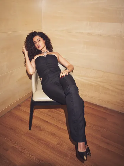 Taapsee Pannu relaxes into her powerful look. The full shot shows the modern tailoring of the Maniere De Voir strapless top and trousers, perfect for a confident statement.