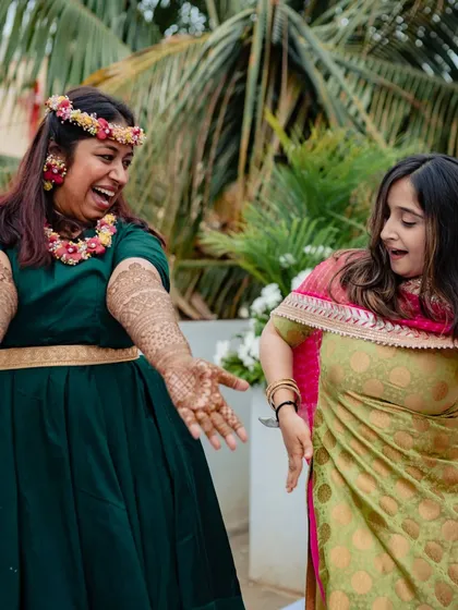 A fun, candid shot of the client dancing and celebrating with a friend during her mehndi event.