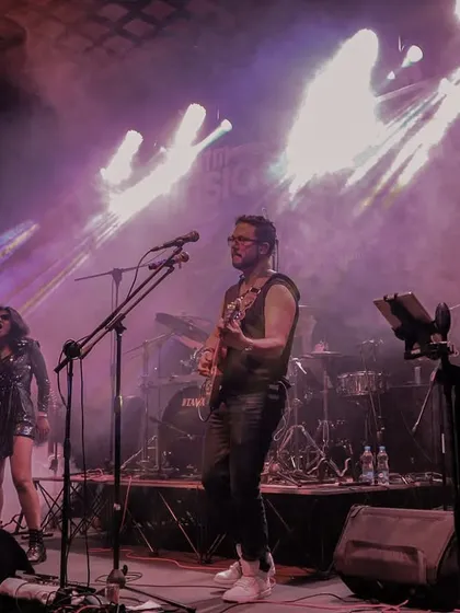 A wide shot of the band on stage, bathed in purple light. This image captures the epic, concert-like feel of our performances.