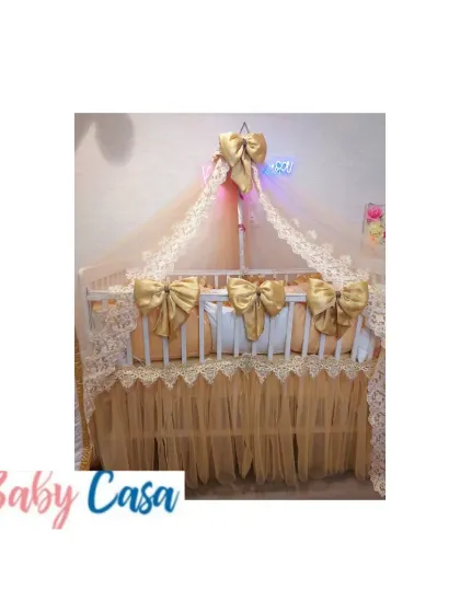 A truly regal nursery design in gold and cream. This crib is adorned with large satin bows, a delicate lace-trimmed canopy, and a matching bed skirt for a look of pure luxury.