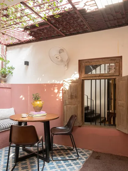 Our studio's outdoor patio is a quiet corner for a cup of coffee or a quick break. We used rustic pink walls and patterned floor tiles to create a warm and inviting atmosphere, making it a small oasis in the middle of the city.
