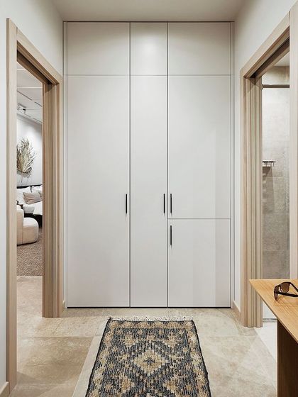 Monotone wardrobes create an illusion of space, making the room feel larger and more elegant. This design uses handleless, floor-to-ceiling white shutters for a clean and minimalist aesthetic.