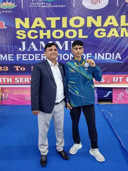 A fencer proudly displays his medal alongside his coach at the 67th National School Games. We celebrate every single victory as a club.
