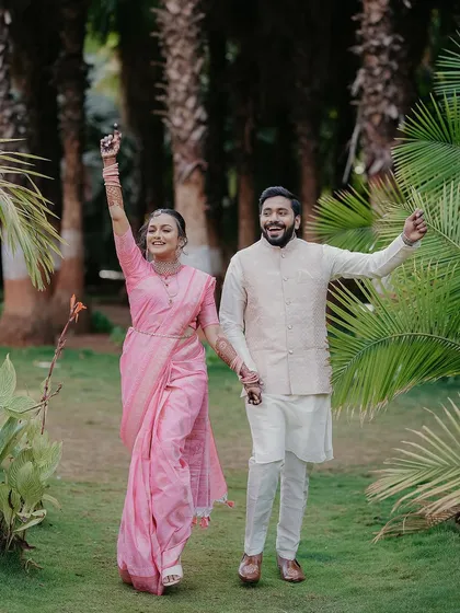 That "we did it" feeling. A celebratory shot of Omkar and Rhutuja walking through a garden after their engagement, full of happiness.