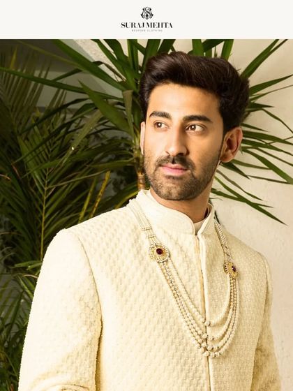 A close-up portrait showcasing the mandarin collar and fit of the off-white sherwani. Every detail is crafted to enhance the wearer's presence.