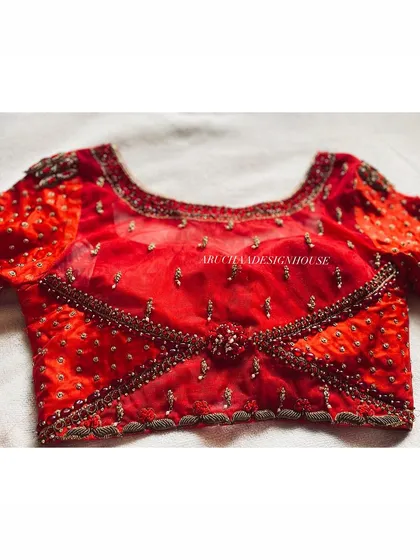The front view of the red wedding season blouse, showing the criss-cross pattern created with beadwork and a central embellished motif.