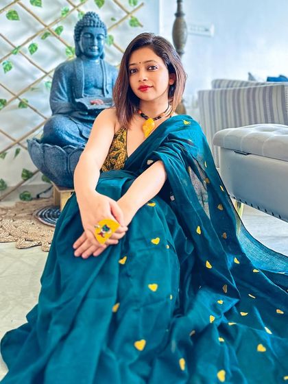 The full view of this gorgeous teal saree. The fabric drapes beautifully, making it comfortable to sit and move in while still looking incredibly put-together.