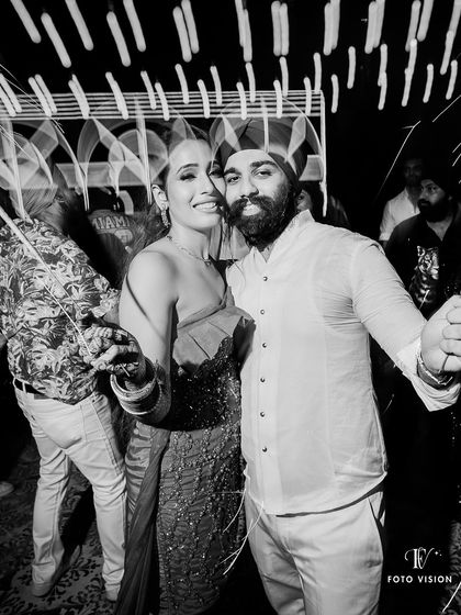 Lighting up the night with sparklers. This photo captures the festive and celebratory atmosphere of an outdoor sangeet party.