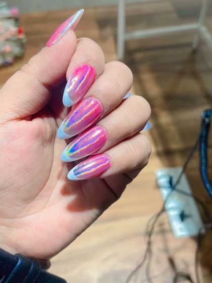 A bold and trendy look featuring a vibrant pink and iridescent chrome effect. The design is finished with a light blue French tip, adding a unique and colorful twist to the holographic style.