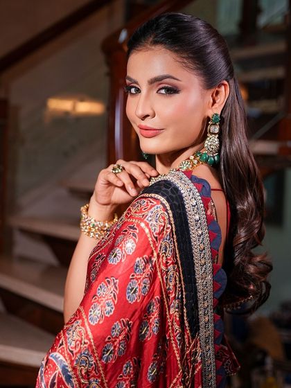 A beautiful profile shot showcasing the makeup and hairstyle. The soft curls and glowing skin create a look that is both romantic and glamorous.