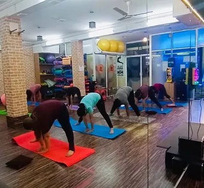 A wide view of our studio during a forward-fold stretch. We have plenty of space for everyone to practice comfortably.