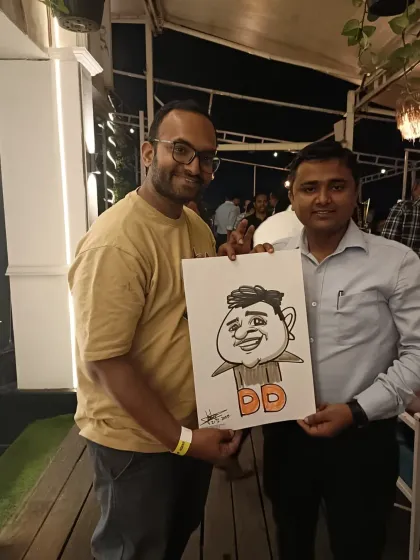 Two friends at Sky Lounge, one holding the caricature of the other. It's a fun group activity.