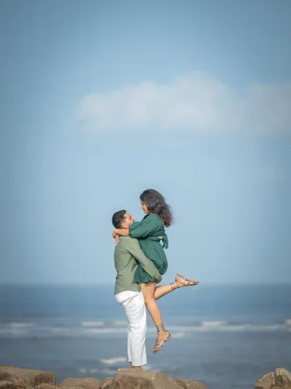 A joyful lift against a perfect blue sky. This pre-wedding photo is all about happiness and captures a beautiful, carefree moment between the couple.