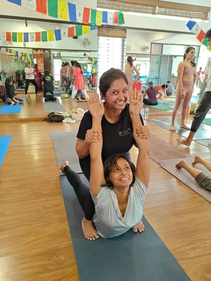 This assisted backbend helps a student go deeper into Bhujangasana (Cobra Pose). The partner provides gentle support to lift the chest and open the heart.