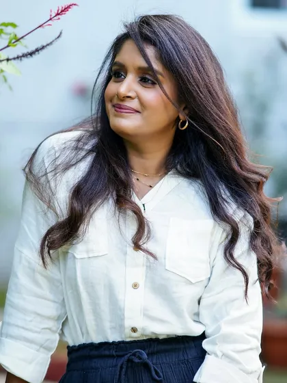 A relaxed and happy outdoor portrait of a woman, looking off to the side with a gentle smile.