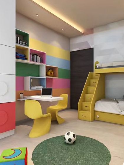This kids' room features a colorful, block-themed modular wardrobe and a yellow bunk bed with integrated stairs. The design includes a dedicated study area, making it a complete and playful space.