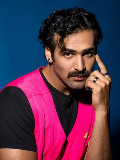 A tight portrait that focuses on the model's expression and the striking color of the vest. The mustache adds a cool, retro vibe.